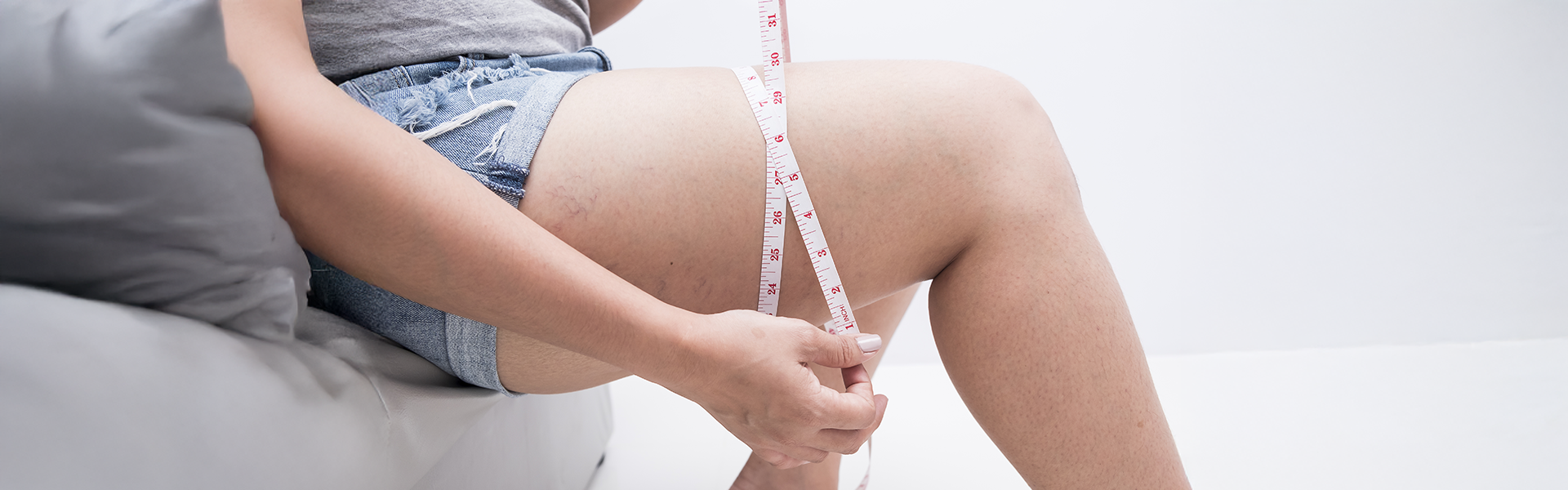 A woman measuring her thighs and showing how to get slim legs without going to the gym.
